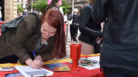 Street work, women signing the petition for a £10 Living Wage
