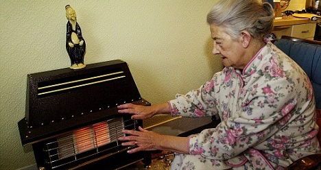 An elderly lady experiencing fuel poverty trying to stay warm at home.